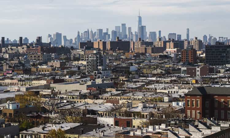 a skyline in the distance with a low-rise suburb in the foreground